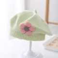 Close-up of a mint green knitted baby beret with a pink flower and ribbed trim detail - 3-48 Months / Fruit Green
