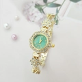 Detailed macro view of the gold flower-shaped bezel and green dial on this luxury watch - Gold Case Green Dial