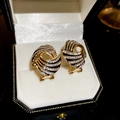 Detailed close-up of retro irregular geometric stud earrings with gold and black enamel - Silver Needle Gold Black Spiral Style