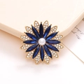 Détail d'une broche fleur dorée avec strass bleus et perle blanche au centre - Bleu Foncé