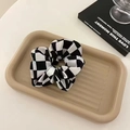 Elegant checkerboard scrunchie in black and white on a stylish textured display tray - Large Grid