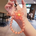Pink macaron beaded phone strap with flower charm and silver clasp for wrist - Orange Flower Orange Beads