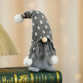 Grijze gebreide kerstkabouter met een lange baard zittend op een oud decoratief boek - Grijs