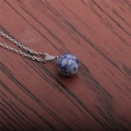 Gros plan d'un pendentif rond en pierre bleue et blanche sur une chaîne argentée - Bleu et Blanc (Pierre à points bleus)