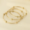 Macro detail of three stacked gold bangle bracelets with decorative polished metal beads - Inner Diameter 60mm / 3 Rings / Gold