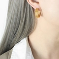 Chic 18K gold plated titanium steel hoop earrings with woven texture on female model - Gold