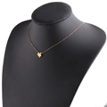 Detail of a gold puzzle piece pendant on a slim chain displayed on a black bust model - 18K Gold