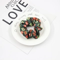 Detail of Christmas scrunchie in green fabric with Merry Christmas print and gift patterns - Dark Green Gifts Red Bows