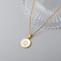 Detail of 18K gold stainless steel necklace with white shell pendant engraved with letter Q - Letter Q Style / Gold