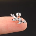 Macro shot of silver leaf-shaped helix piercing with cubic zirconia on a fingertip - Silver Leaf Branch Stud