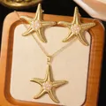 Detailed view of starfish jewelry set with white pearls in a wooden display tray - Gold Pearl Starfish Set (Necklace+Earrings)