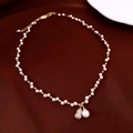 Detailed close-up of a French pearl necklace with a pavé zircon gourd pendant on red velvet - Gold-White (Gourd Pendant)