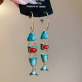 Nahaufnahme eines Vintage Fisch-Quastenohrrings mit pfauenblauem Emaille und Gelenken - Gold-Blau