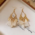 Close-up of bohemian gold leaf earrings with long cream tassels on a display tray - 36# Ear Hook - White Tassel
