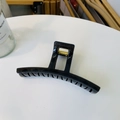 Detail of a large black geometric hair claw clip with a strong gold metal spring mechanism - Translucent Grey Green