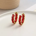 Macro detail of red rectangular zircon stone set in a vintage gold earring on a tray - Red (ZYN-DME454G-2)