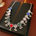 Dettaglio macro della collana vintage con fiori, gemme colorate e campanellini in metallo - Collana - Argento