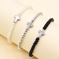 Detailed view of three elastic beaded bracelets in white, silver, and black with cross charms - Silver Cross 3-Piece Set