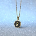Golden round pendant necklace with black enamel inlay and letter R on blue background - Letter R