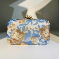 Dettaglio del ricamo floreale con fili blu e dorati e accenti di perle sulla borsa - Ricamo Floreale Argento