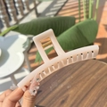 Large cream-colored butterfly hair claw clip held by hand against a natural background - Greek-letter Shaped Extra Large Butterfly Buckle / Off-white (Approx 13.5cm)