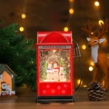 Macro shot of retro red fuel pump snow globe lamp with happy holidays sign and snowmen - Three Snowmen