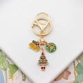 Detailed close-up of golden Christmas keychain with bell, wreath, and tree charms - Bell Wreath Christmas Tree