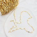 Makroaufnahme von Details der Gold-Kreuzkette auf weißer Spule und Display-Tablett - Breite 5mm / KC Gold