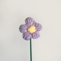 Handgefertigte lila Häkelblume mit gelben Staubblättern und grünem Stiel aus Garn - Lila