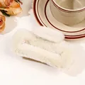Detailed close-up of cream fuzzy plush claw clip on a table with vintage floral accents - 11cm Square Plush Claw - Beige
