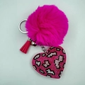 Detail of pink faux fur pom-pom with leopard print rhinestone heart charm and tassel - Rose Red