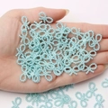 Light blue pearl bow beads held in hand showing detailed DIY craft accessory size - Lake Blue