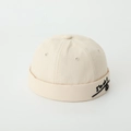Detail of embroidered smile face and text on beige cotton brimless docker hat - 52cm / Beige
