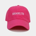 Détail de la broderie Brooklyn blanche sur une casquette de baseball en coton rose - Réglable / Rose Rouge