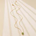 Detailed close-up of a delicate gold chain necklace featuring a round green gemstone pendant - Green Round Style (BD022-green)