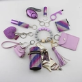 Purple self-defense keychain set featuring a rhinestone alarm, wallet, and wristlet charm - Violet