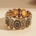 Macro view of vintage gold elastic bracelet with intricate radial sunburst textures - Gold