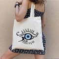 White canvas tote bag featuring graffiti Greek Evil Eye print shown on a model's shoulder - STD1804-R Blue Artistic Print