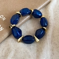 Dettaglio di perline in acrilico blu glitterato e distanziatori geometrici dorati su lino - Bracciale-Blu