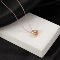 Collar de acero inoxidable oro rosa con corazones entrelazados sobre soporte blanco - Oro rosa