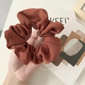 Handheld view of a large brown ribbed fabric scrunchie with high elasticity - Red Stripe