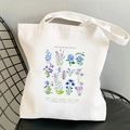 Off-white canvas tote bag featuring botanical blue and purple floral art prints - Blue and Purple Flowers Chart