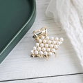 Elegant gold metal hair claw clip with white pearls on white wooden surface - Diamond Gold