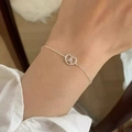 Detail of silver chain bracelet with heart knot pendant and white zircon on woman's wrist - Silver Heart Bow Zirconia (MY36670)