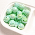 Macro shot of 14mm light green iridescent acrylic round beads in a ceramic tray - Light Green