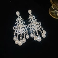 Dettaglio di orecchini a nappa argentati con strass brillanti ed effetto di luce a forma di stella - Argento (Perno in argento)