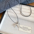 Detail view of the silver pony pendant necklace inside a linen lined jewelry box - Silver Enamel Horse Pendant with Black Cord
