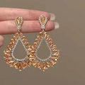 Macro detail of teardrop hollow earrings with champagne crystals and gold finish - Hollow Gold Water Drop