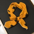 Élégant foulard jaune avec motif trèfle noir noué en nœud sur un plateau noir - 55x55cm / Pigamon Jaune