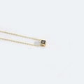 Minimalist gold square pendant necklace with a black face featuring the letter R design - Letter R